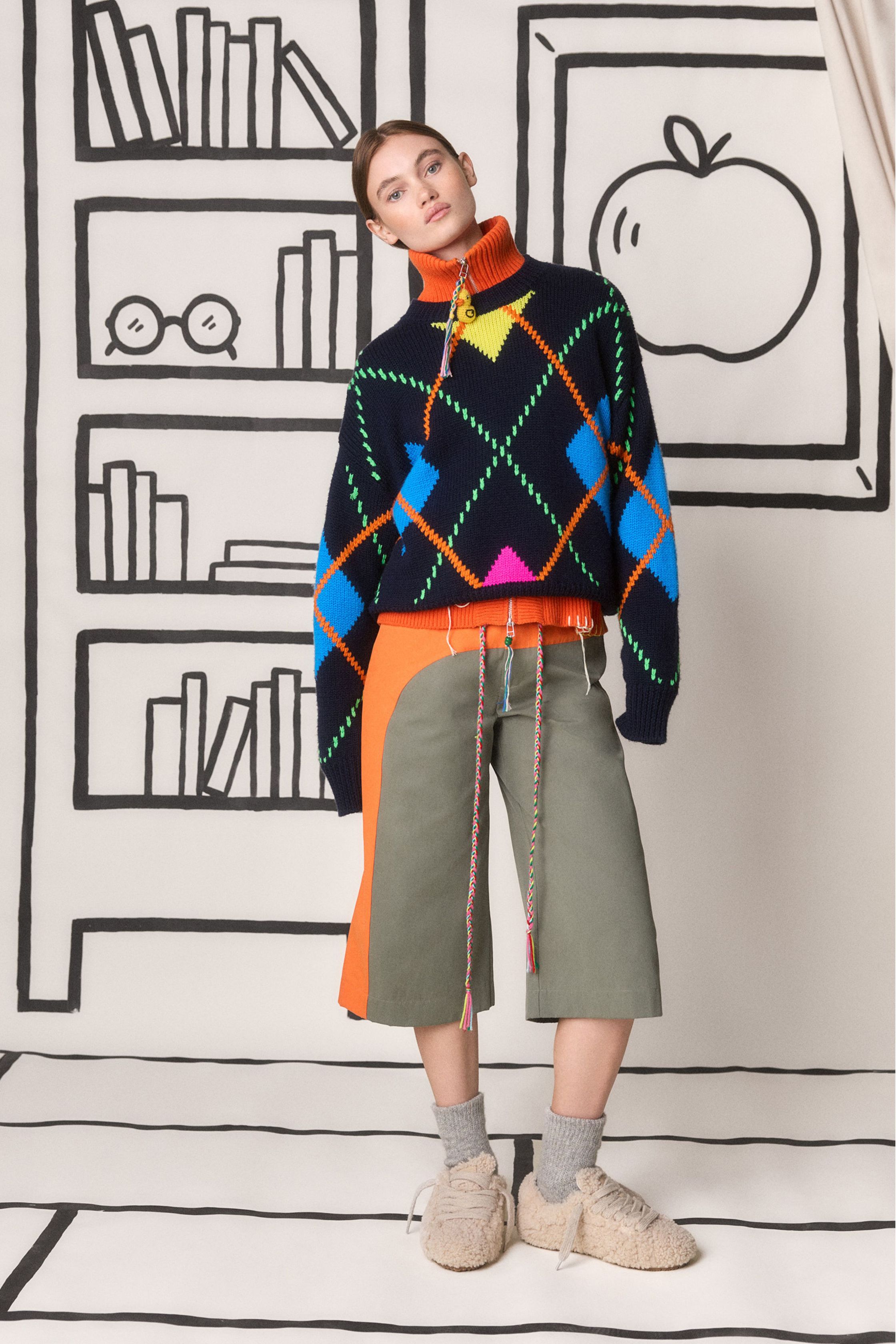 Mira Mikati 本季继续以充满童趣的视觉语言构建一个轻松而充满想象力的衣橱：卡通刺绣、学院领带、彩色针织和宽松半裙构成一个介于校园与艺术工作室之间的世界。鲜亮黄色、菱格针织和手绘背景让整场秀像一本立体绘本，充满快乐与创意-顽石频道趋势研究